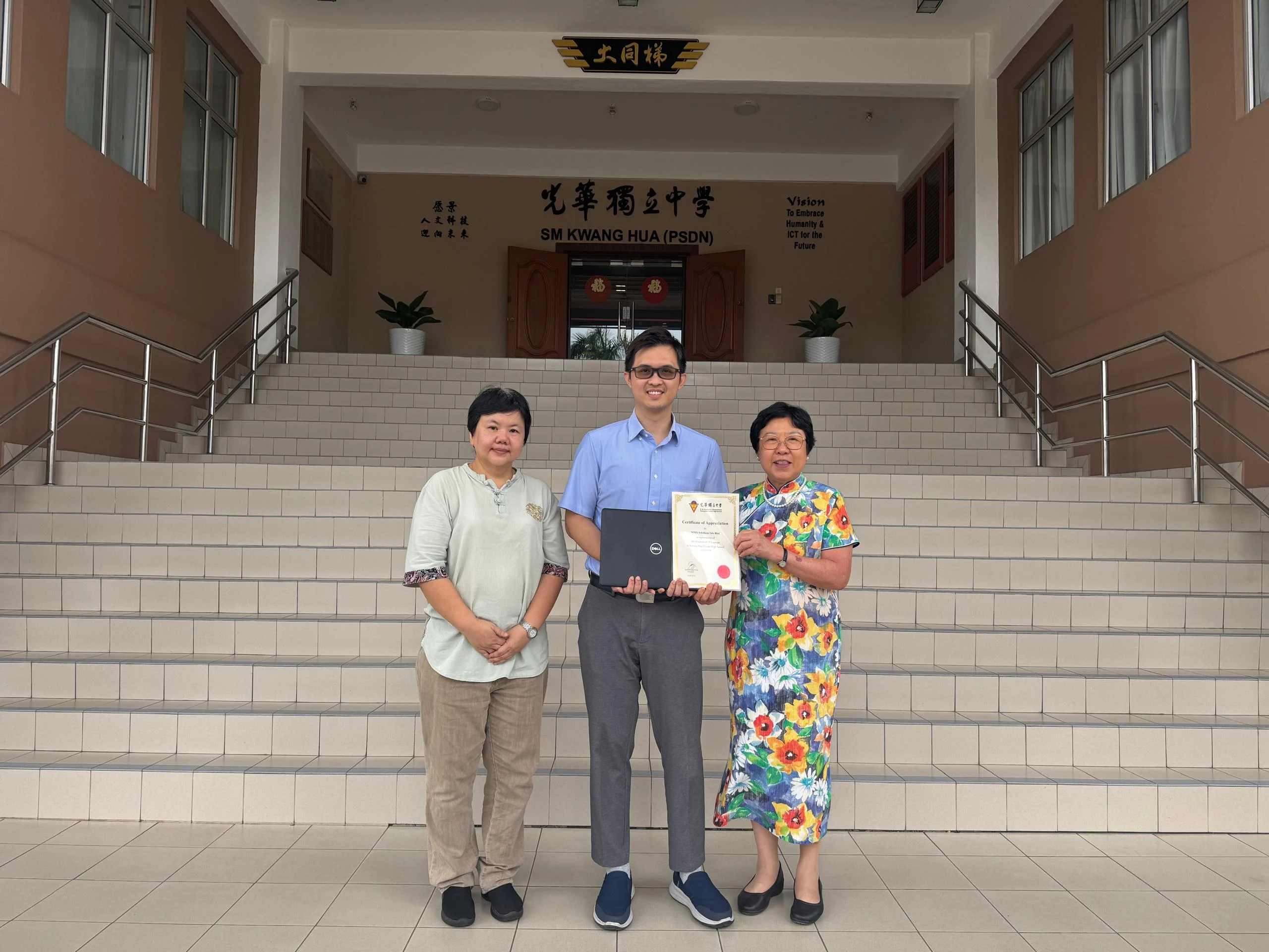 MMX Solutions Director Raymond Tiew presenting the laptop donation and receiving a Certificate of Appreciation at Kwang Hua Private High School